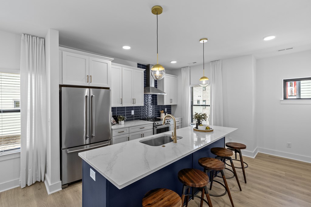 A kitchen with a marble countertop and stainless steel appliances.