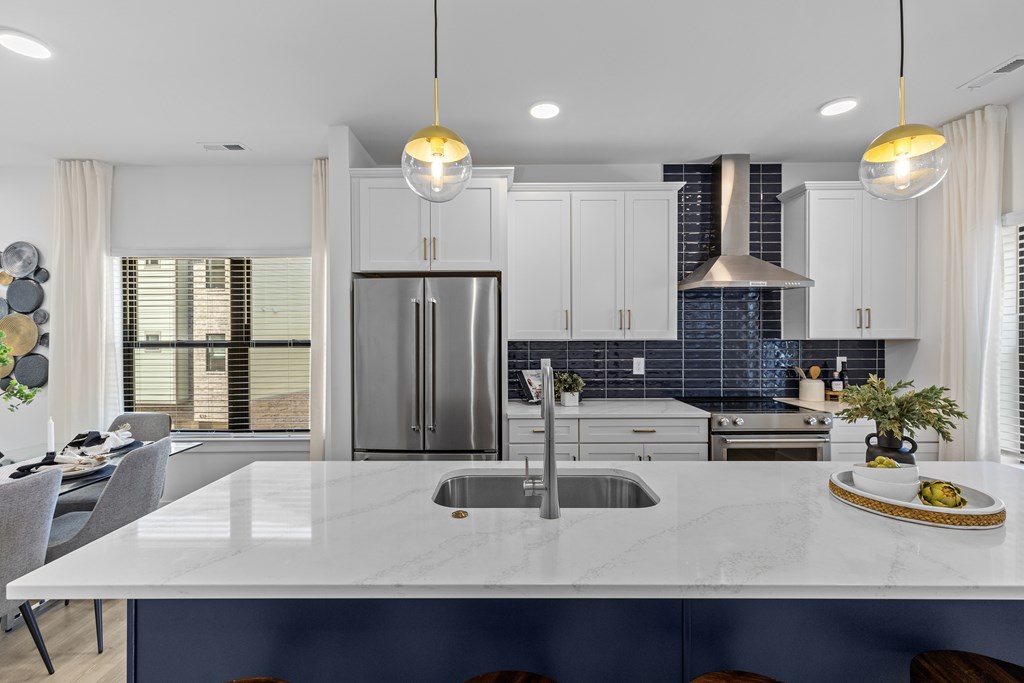 A modern kitchen with a large island and stainless steel appliances.