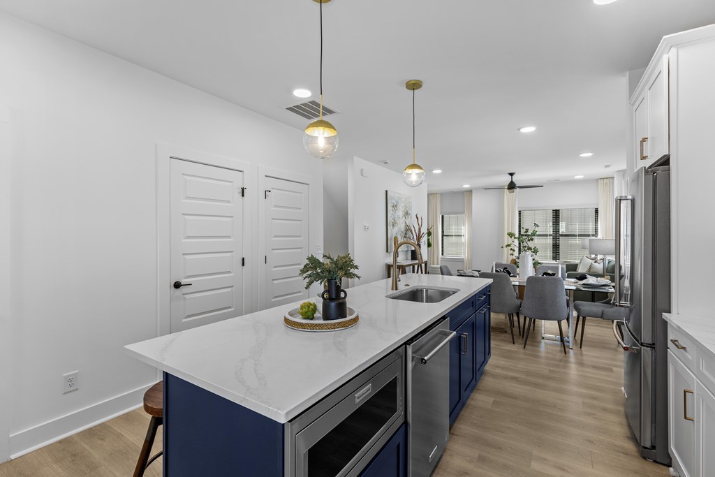 A modern kitchen with a white countertop and blue cabinets.