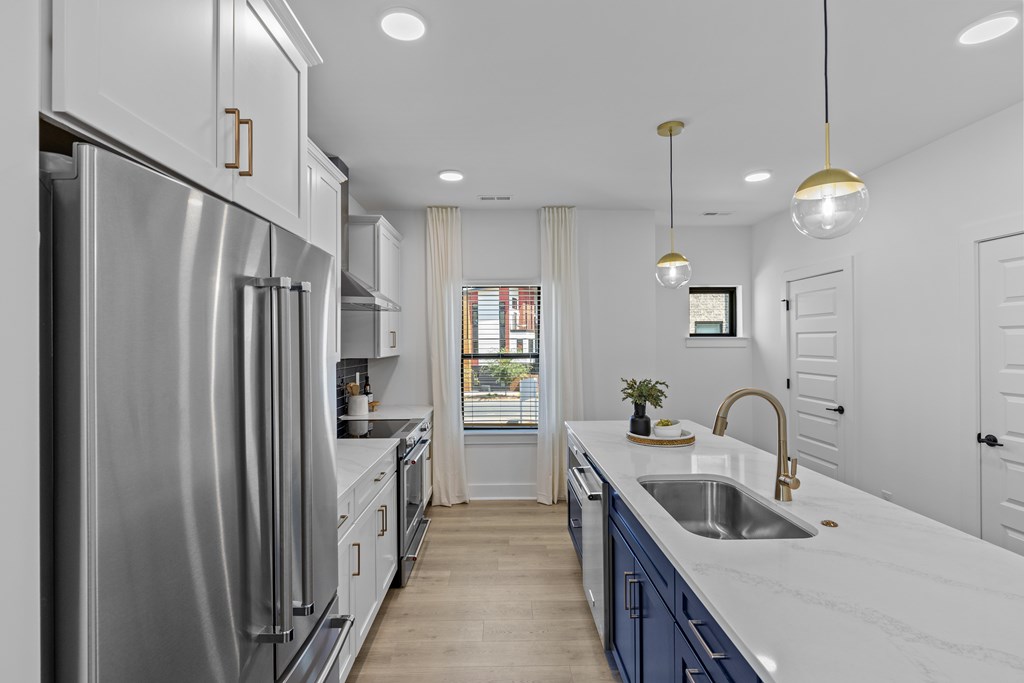 A modern kitchen with a large refrigerator and a marble countertop.