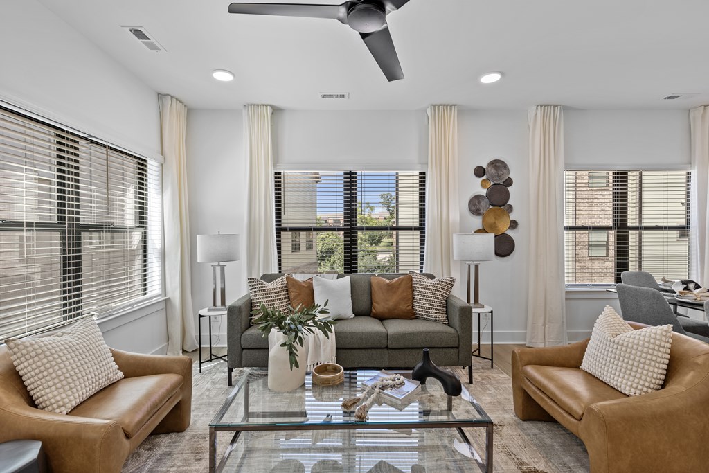 A modern living room with a glass coffee table and two couches.