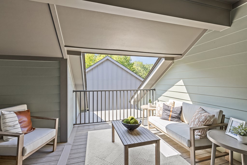 A patio with a couch, chairs, and a table with a bowl of fruit on it.