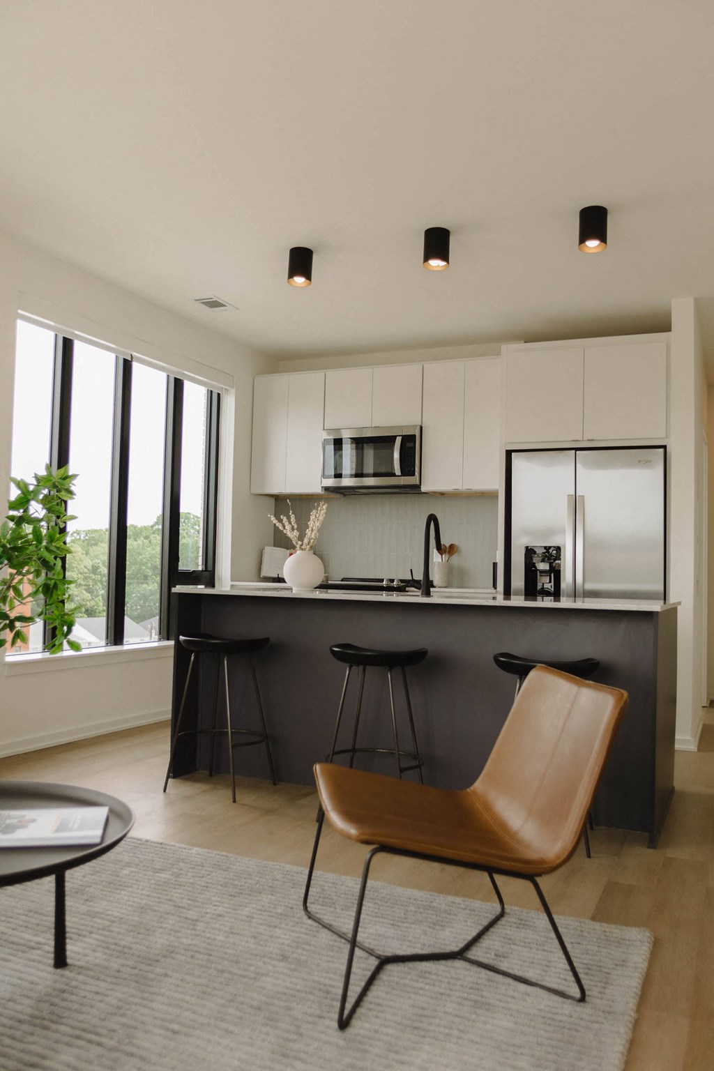 a kitchen with white cabinets and a black counter