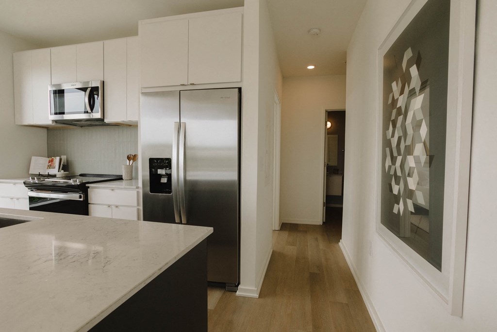 a kitchen with white cabinets and a stainless steel refrigerator