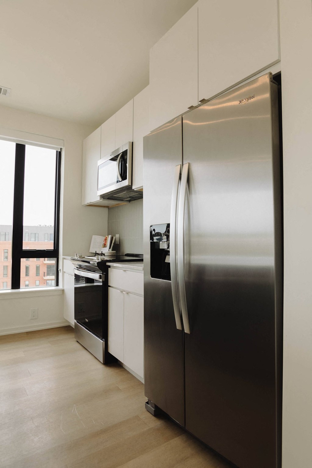 a kitchen with a stainless steel refrigerator and a window