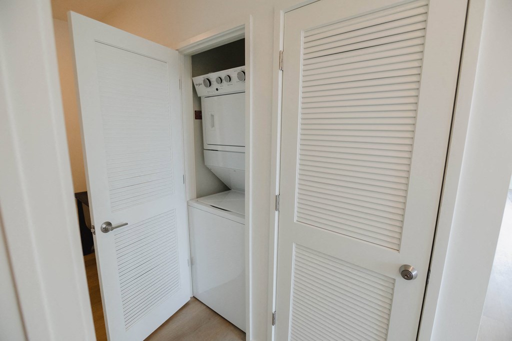 the closet has a washer and dryer in it and the door is closed