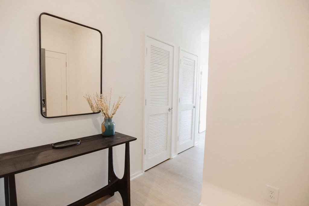 a hallway with a mirror and a door to a closet