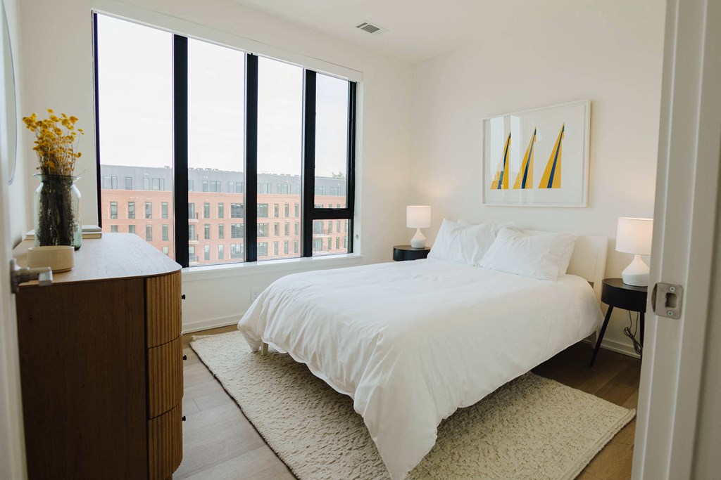 a bedroom with a large bed and tall windows