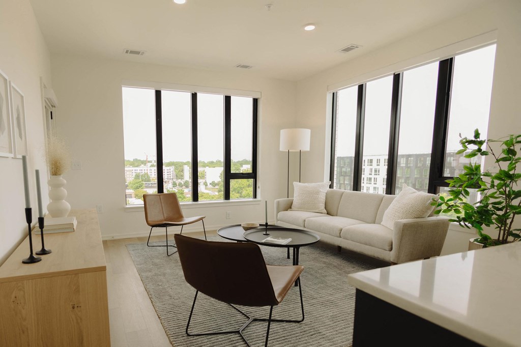 a living room with a couch and a table and some windows