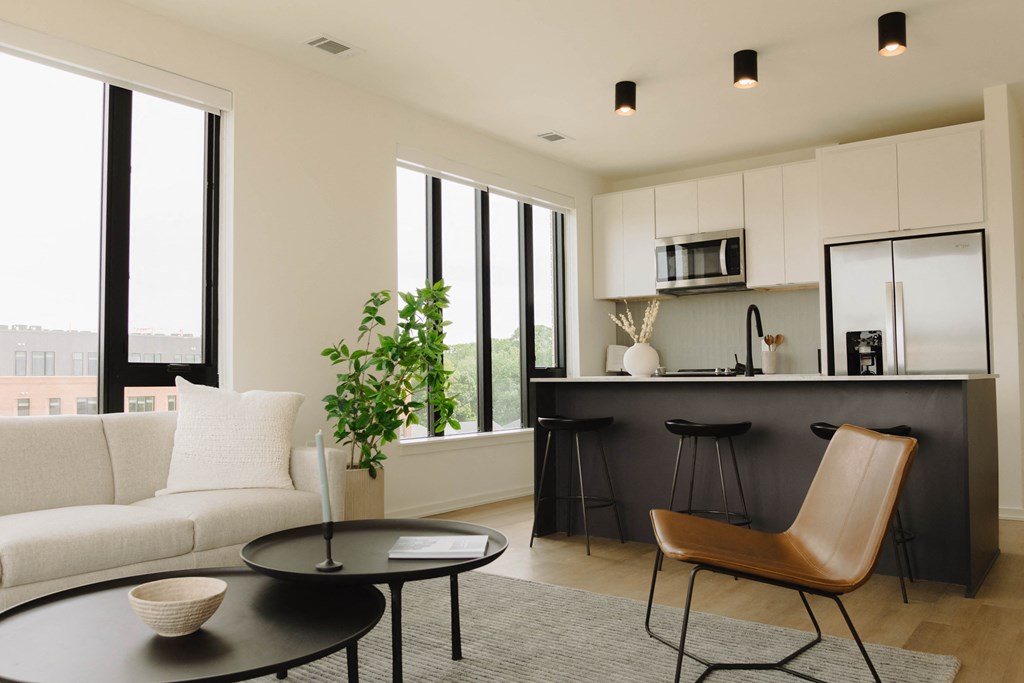 a living room with a white couch and a kitchen with a black