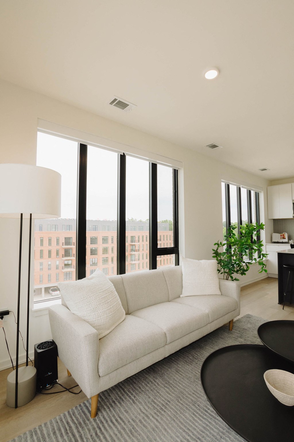 a living room with a white couch and large windows