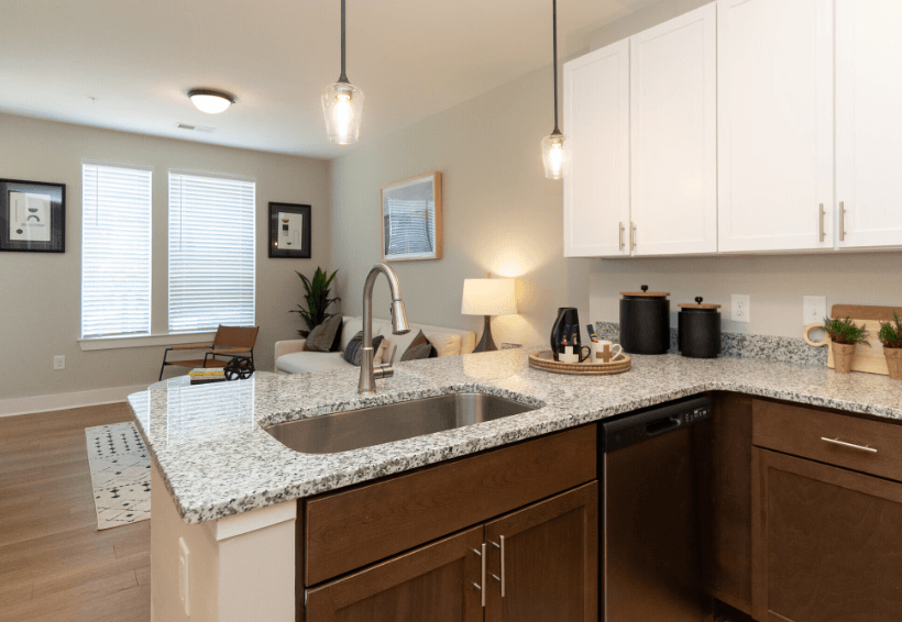 A kitchen with a sink, cabinets, and a window.