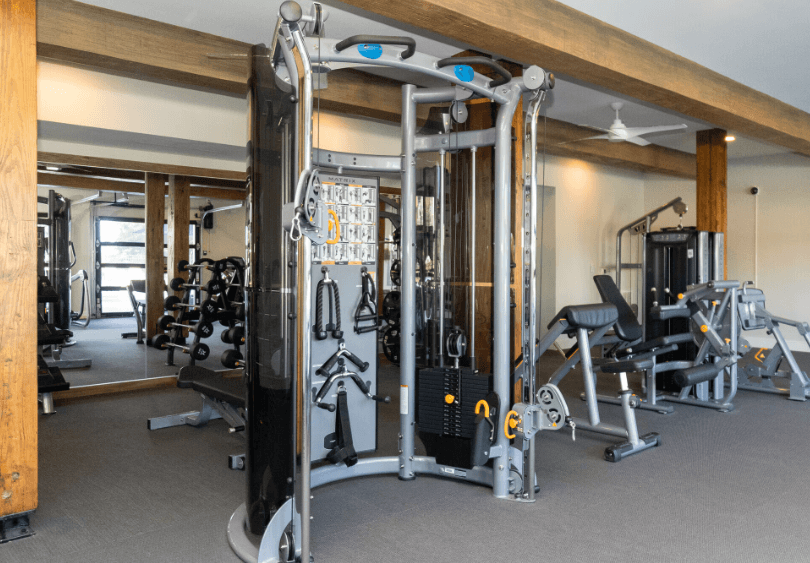 A gym with a variety of equipment including a squat rack.