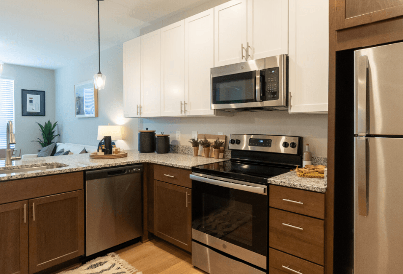 A modern kitchen with stainless steel appliances and wooden cabinets.