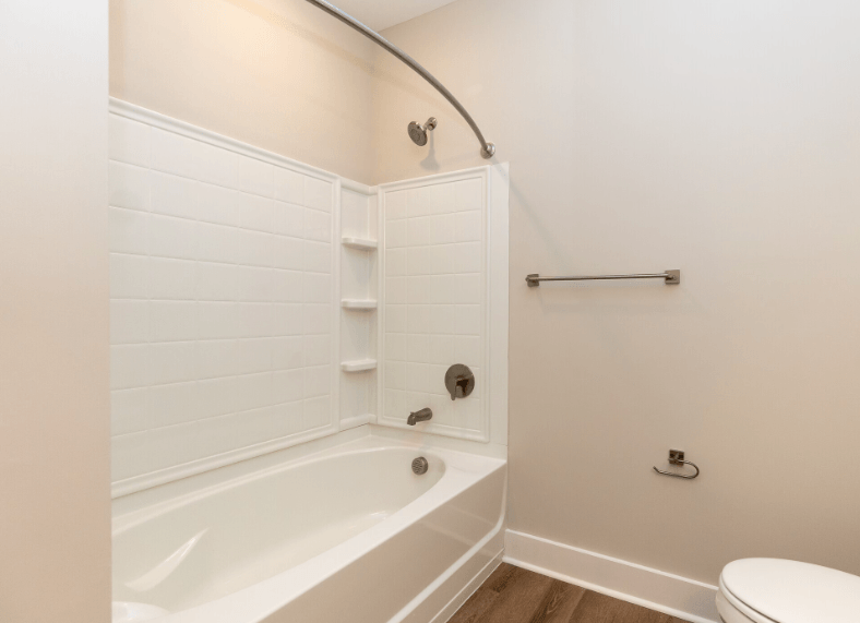 A white bathroom with a tub, toilet and sink.