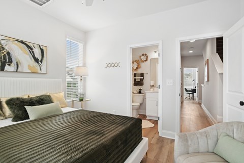 A bedroom with a large bed and a painting on the wall.