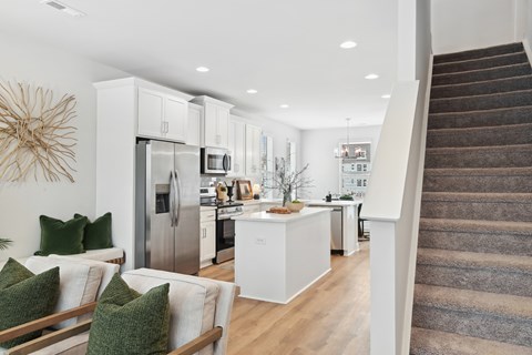 A modern kitchen with a staircase leading to the upper floor.