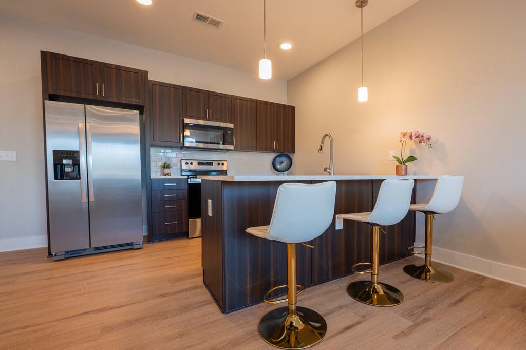 a kitchen with stainless steel appliances and a bar with white chairs at Park View Greer, South Carolina, 29365