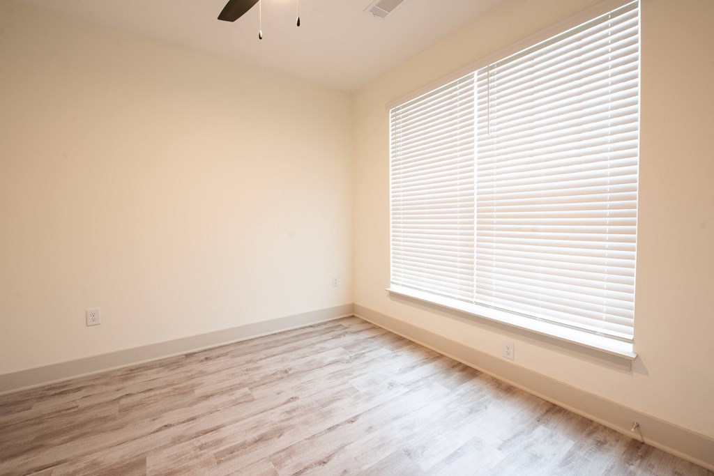 a living room with a large window and wood floors