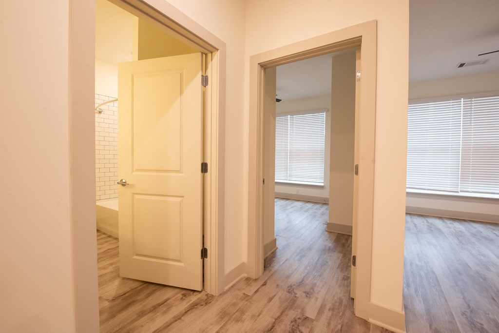 a bedroom with a door to a bathroom and a closet