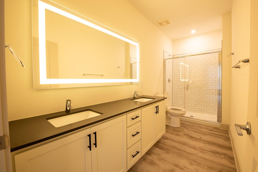 a large bathroom with two sinks and a shower