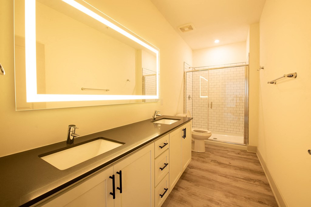 a large bathroom with two sinks and a shower