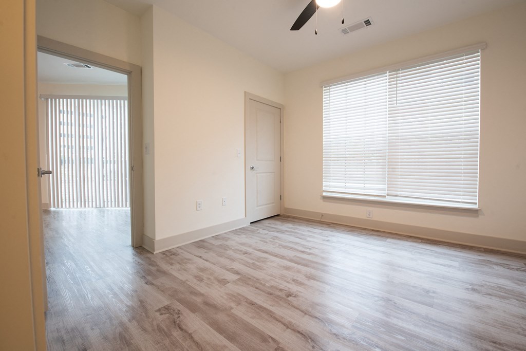 an empty living room with wood floors and a window