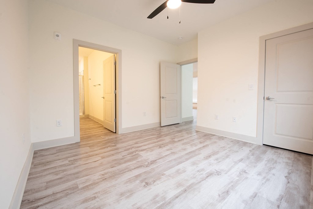 an empty living room with white walls and wood floors
