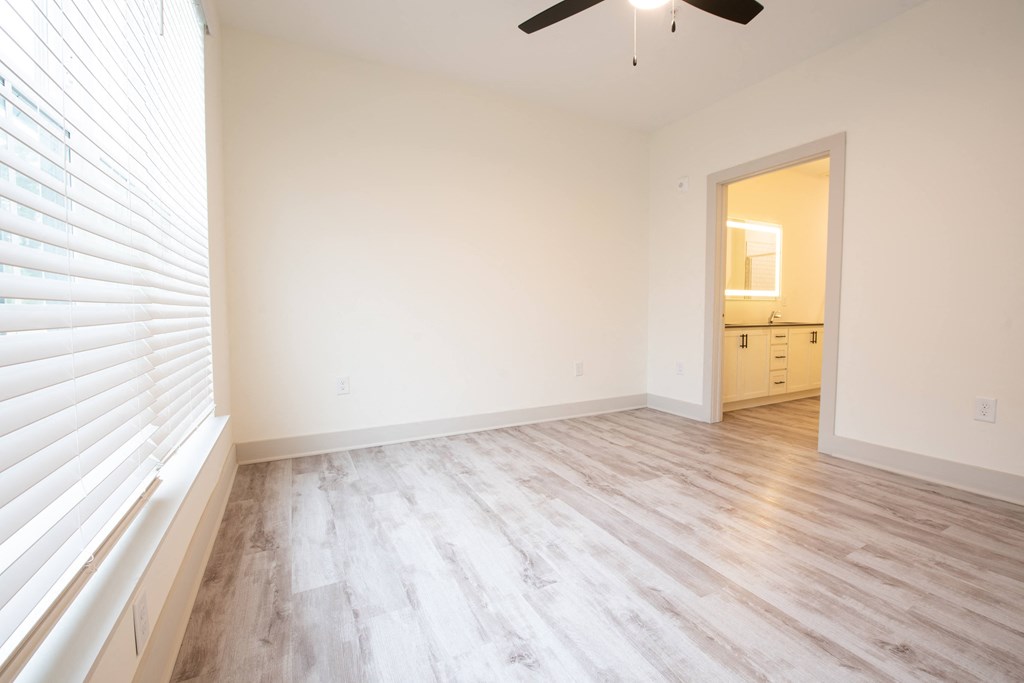 an empty living room with white walls and wood floors