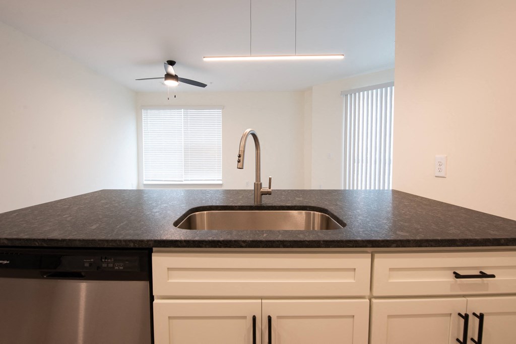a kitchen with granite counter tops and a stainless steel sink