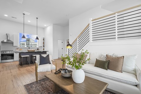 A modern living room with a white couch and a wooden coffee table.
