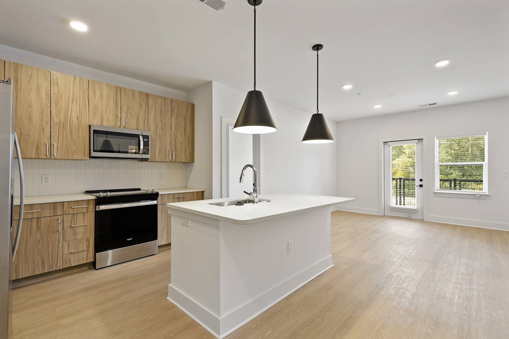A kitchen with a white island and wooden cabinets.
