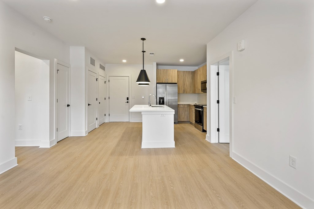 A kitchen with a white island and wooden floors.