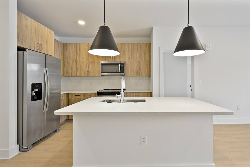 A modern kitchen with a white island and stainless steel appliances.
