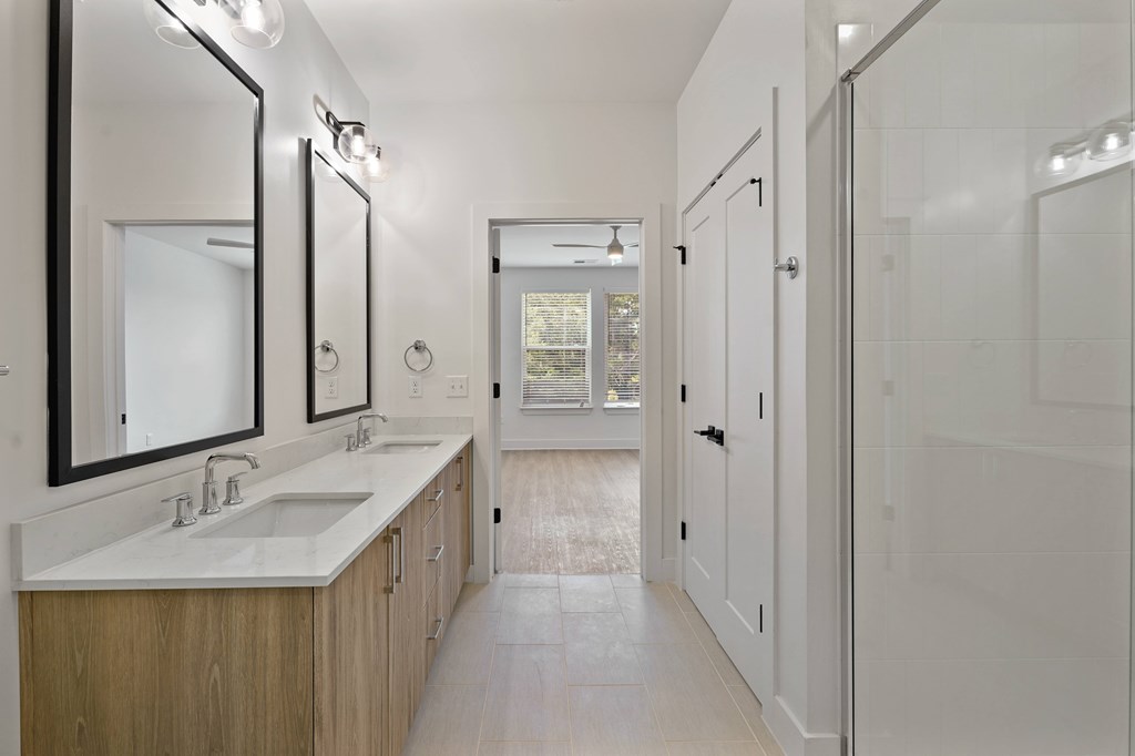 A bathroom with a white sink and mirror.
