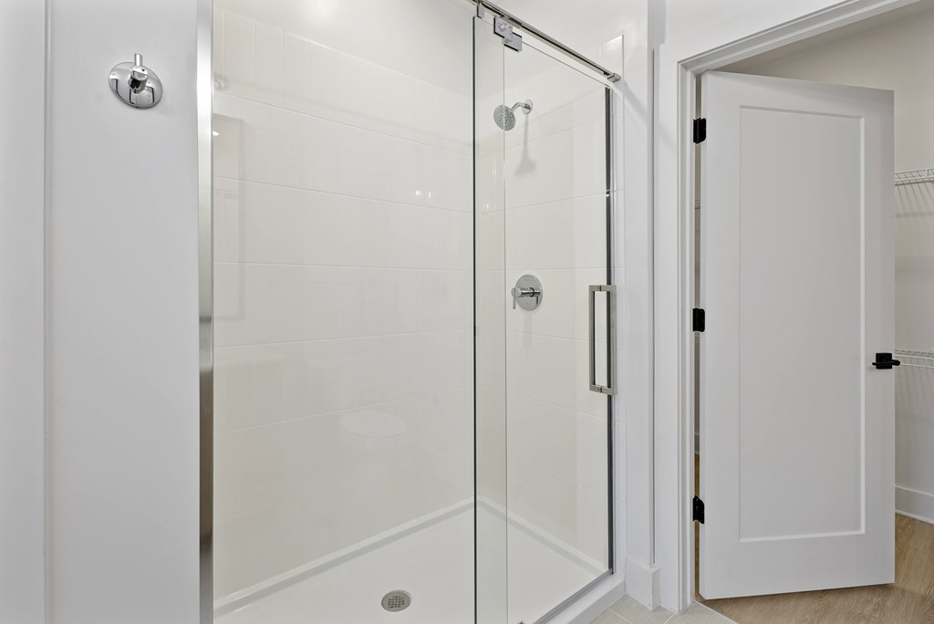 A white bathroom with a glass shower door.