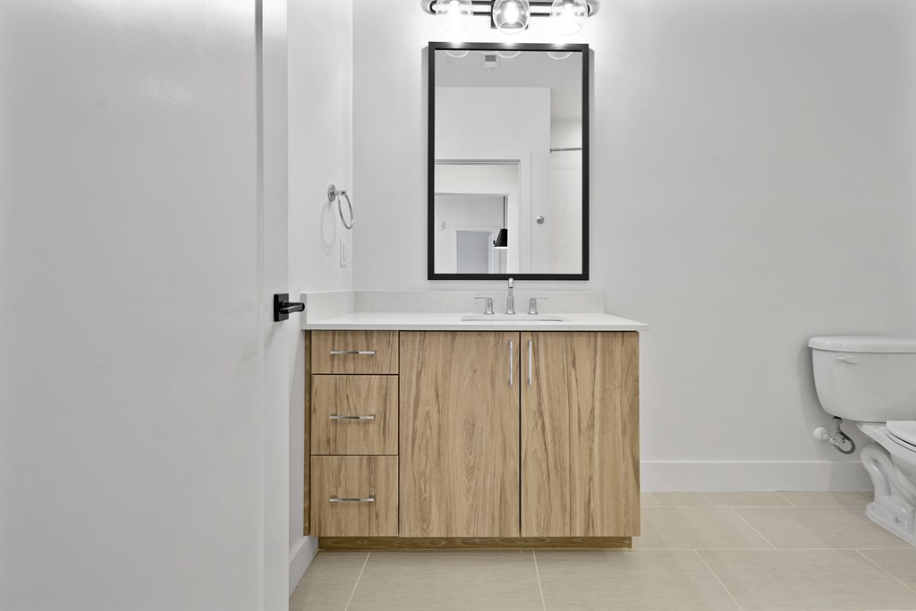 A bathroom with a wooden cabinet and a white toilet.