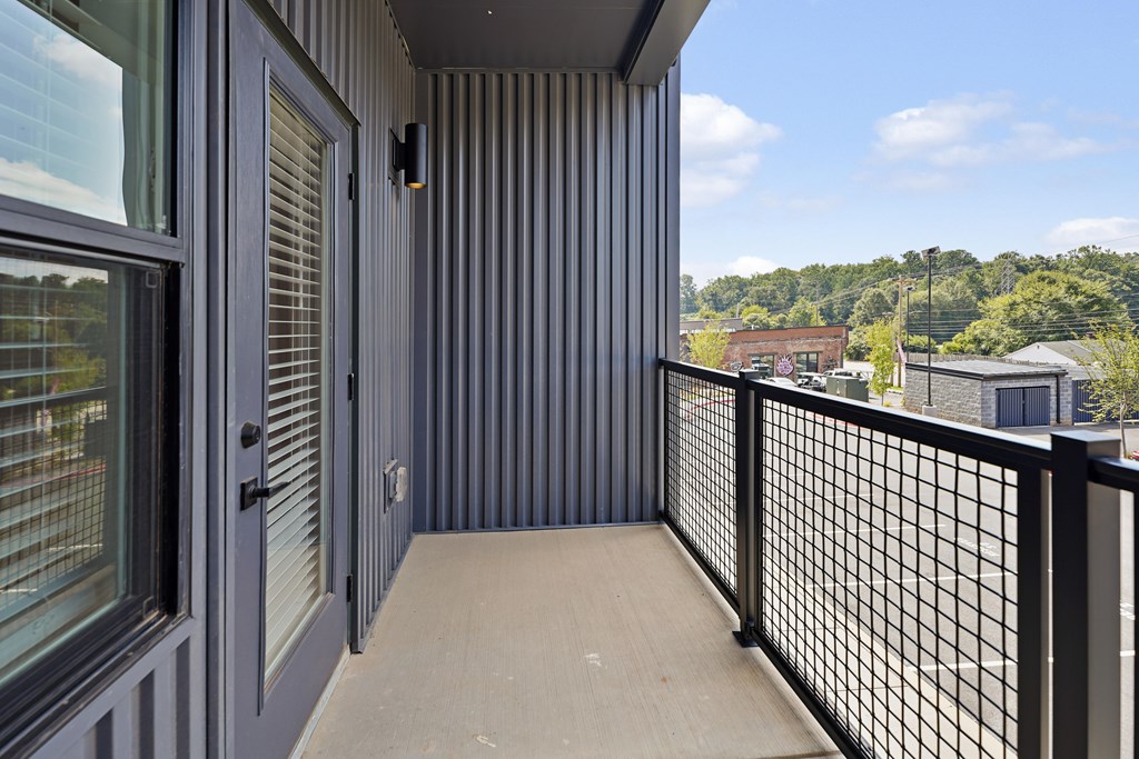 A balcony with a black railing and a view of the outdoors.