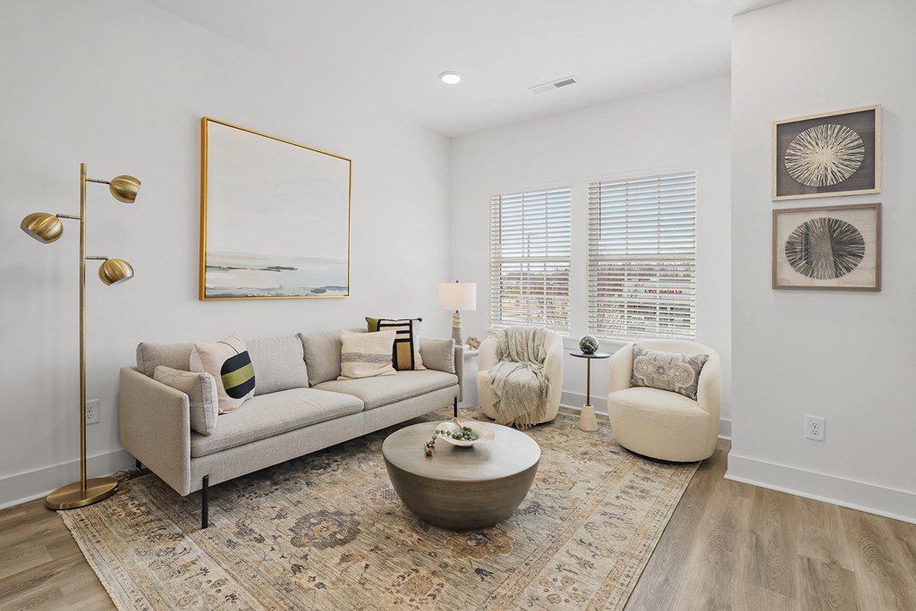 A living room with a grey couch, a coffee table, and a large mirror.