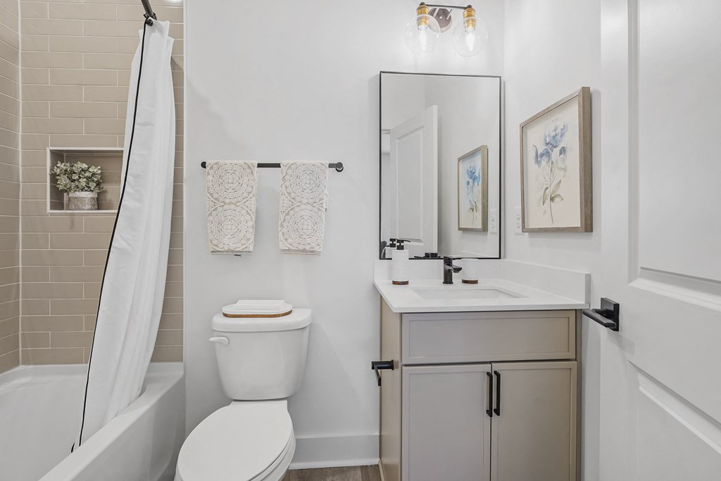 A white toilet sits next to a white sink in a bathroom.
