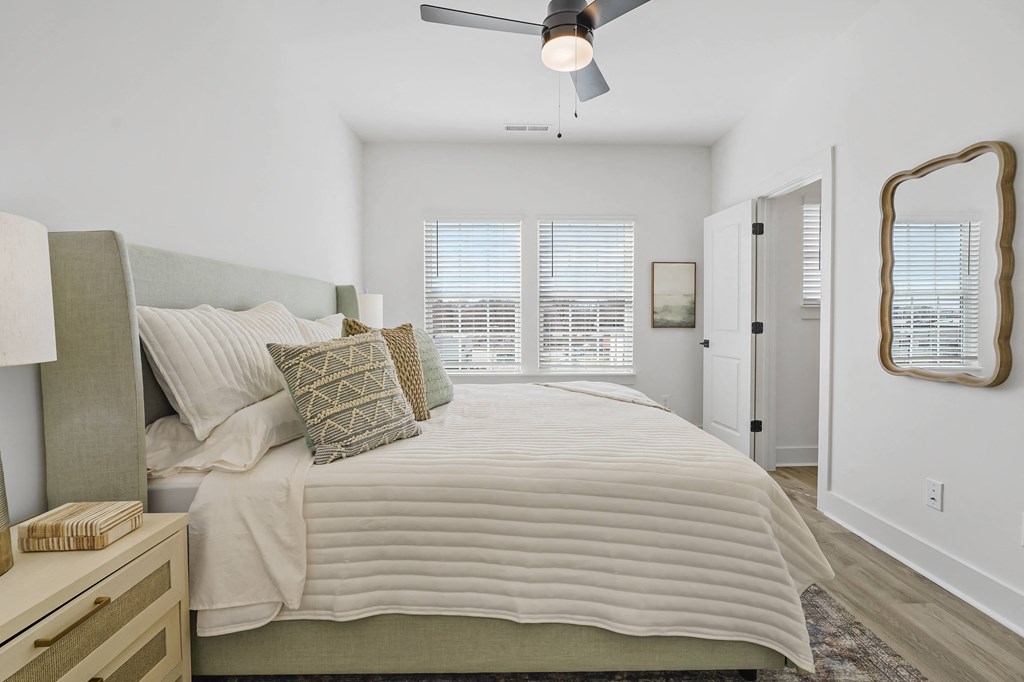 A bedroom with a large bed and a ceiling fan.