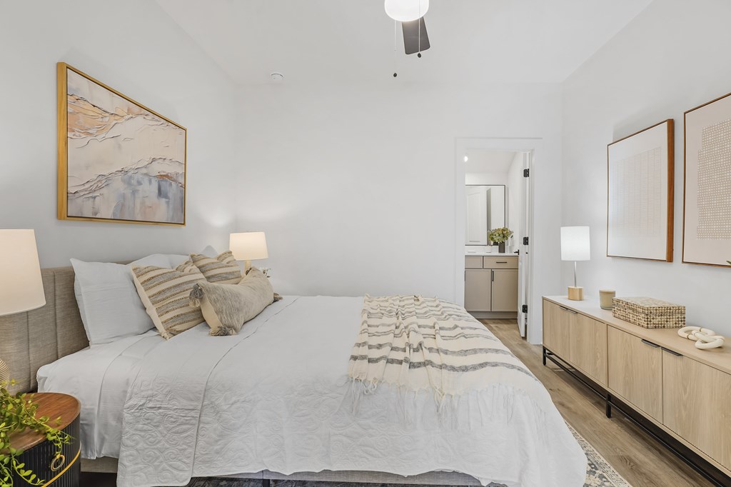 A bedroom with a large bed and a painting on the wall.