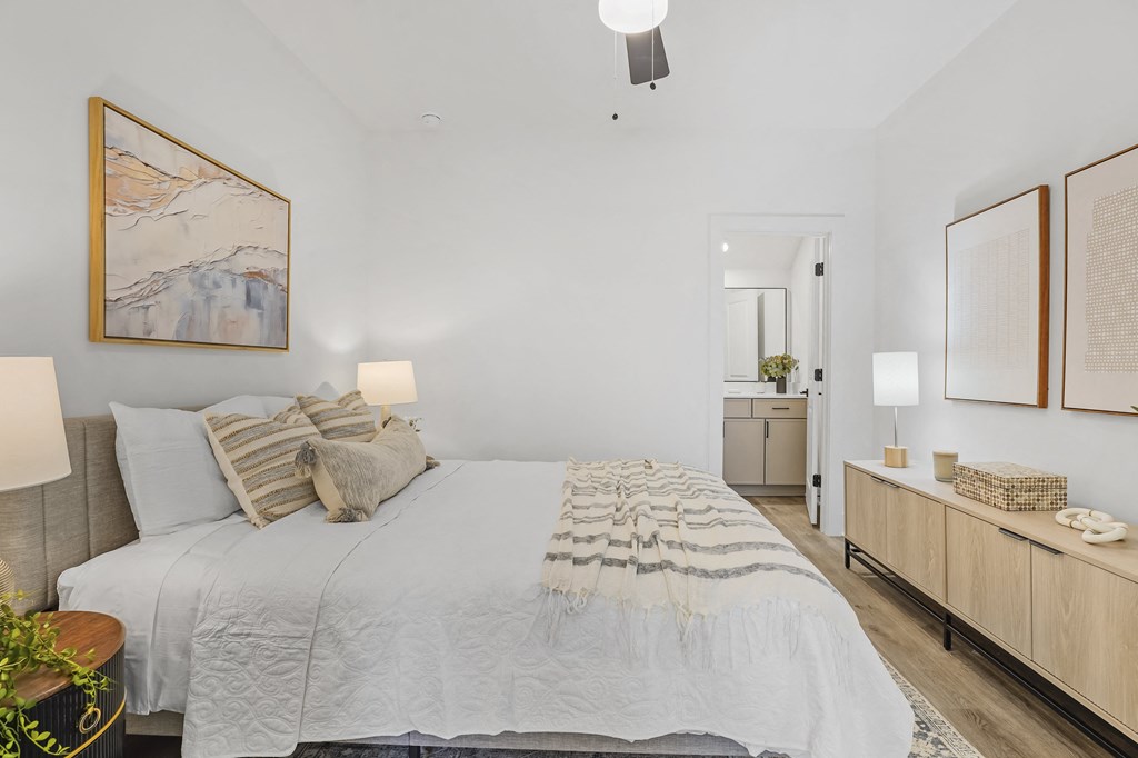 A bedroom with a large bed and a painting on the wall.