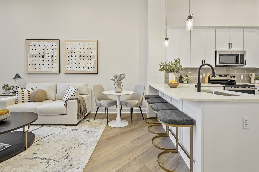 A modern kitchen with a white couch and a bar stool.