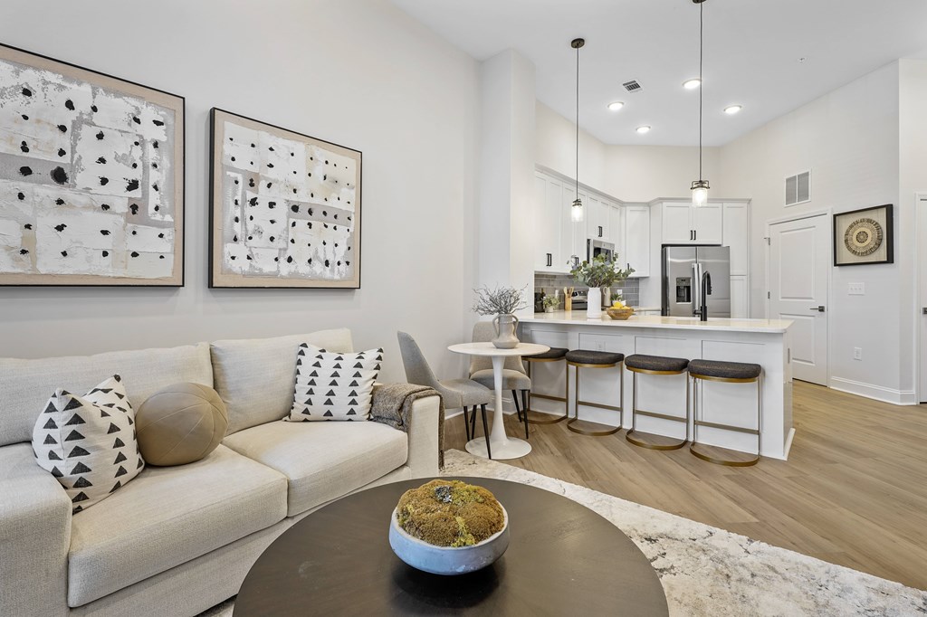 A modern living room with a white couch and a coffee table with a bowl of food on it.