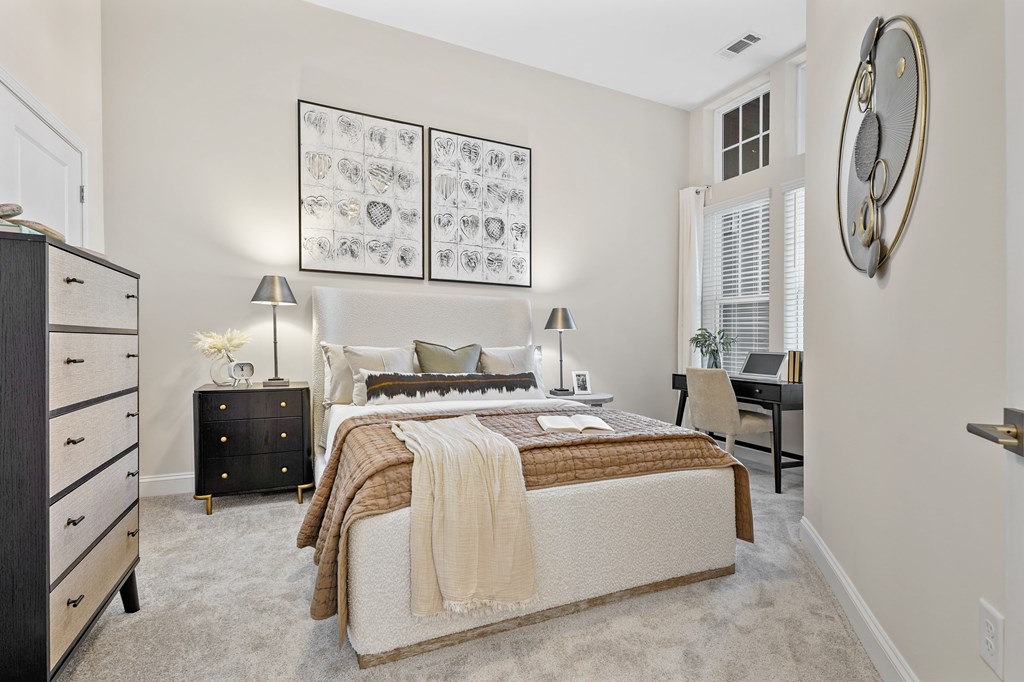 A bedroom with a bed, nightstand, and two lamps.