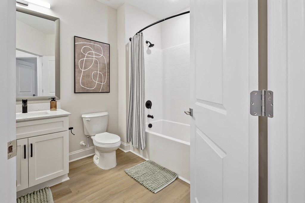 A bathroom with a toilet, sink, and shower.