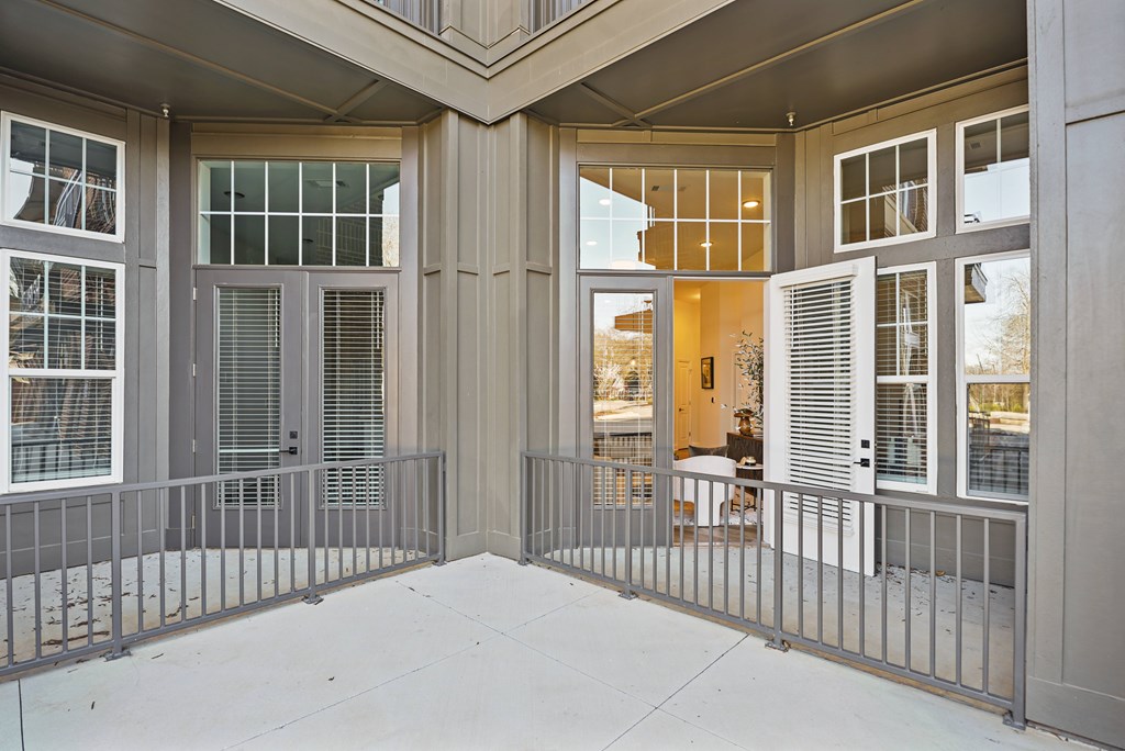 A modern house with a grey facade and a glass door.