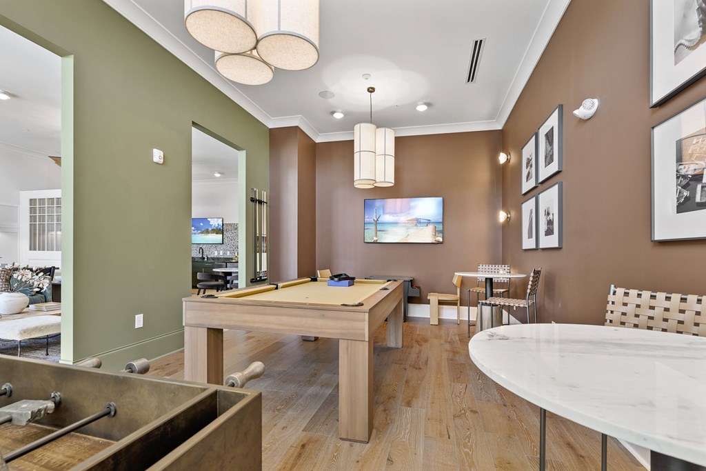 A room with a pool table and a tv.