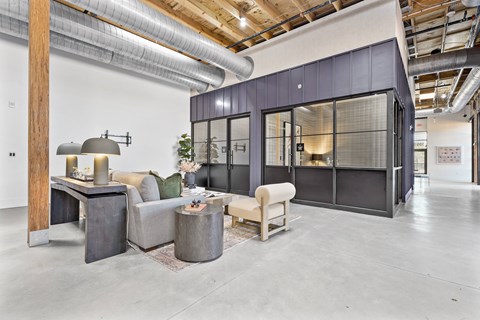 A modern living room with a grey couch and a wooden table.